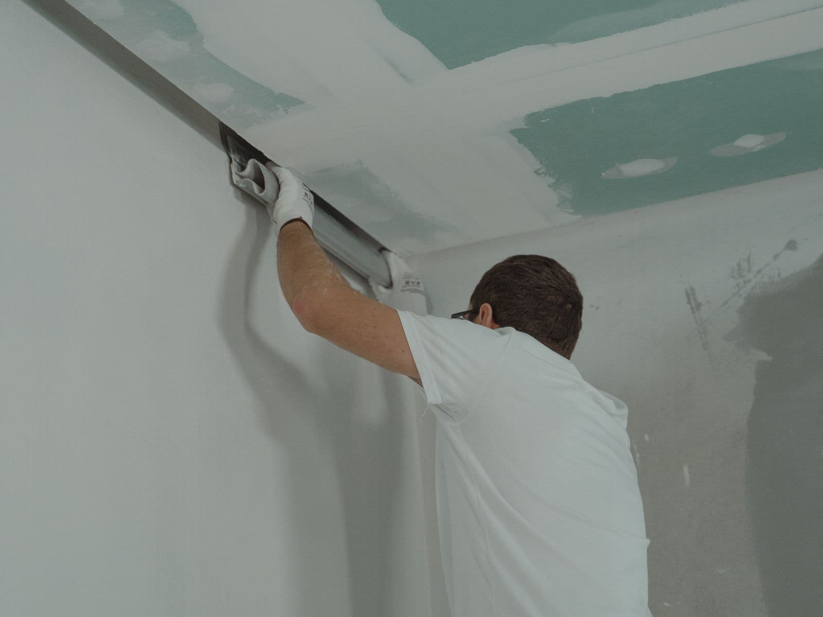 Finishing a drywall ceiling seam with a trowel
