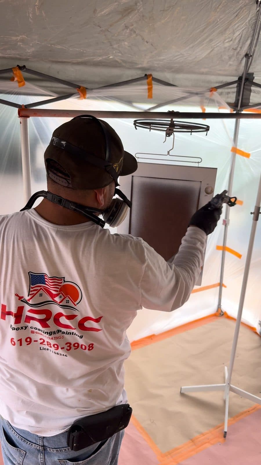 HRCCoatings crew spraying a cabinet door in a sealed spray tent